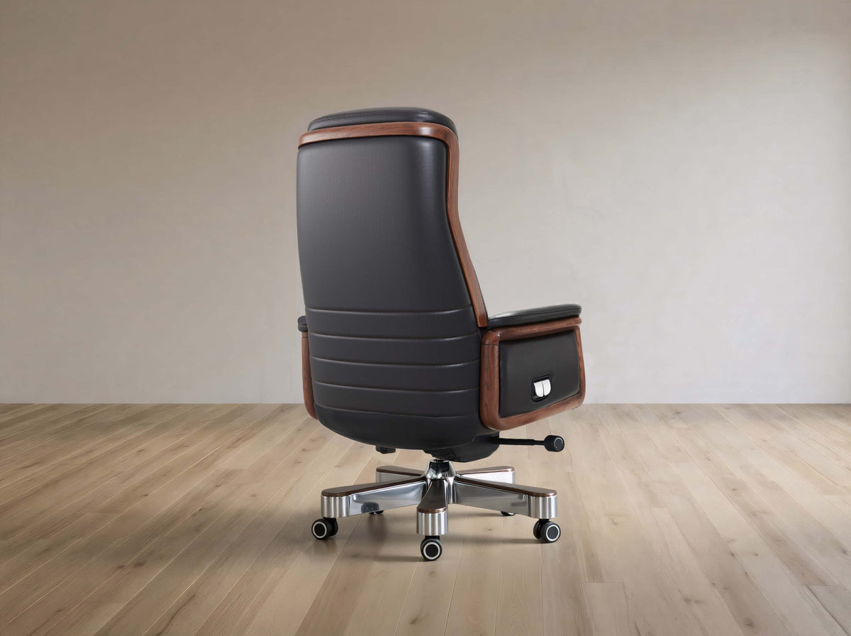Black office chair with brown accents on a wooden floor and beige wall background