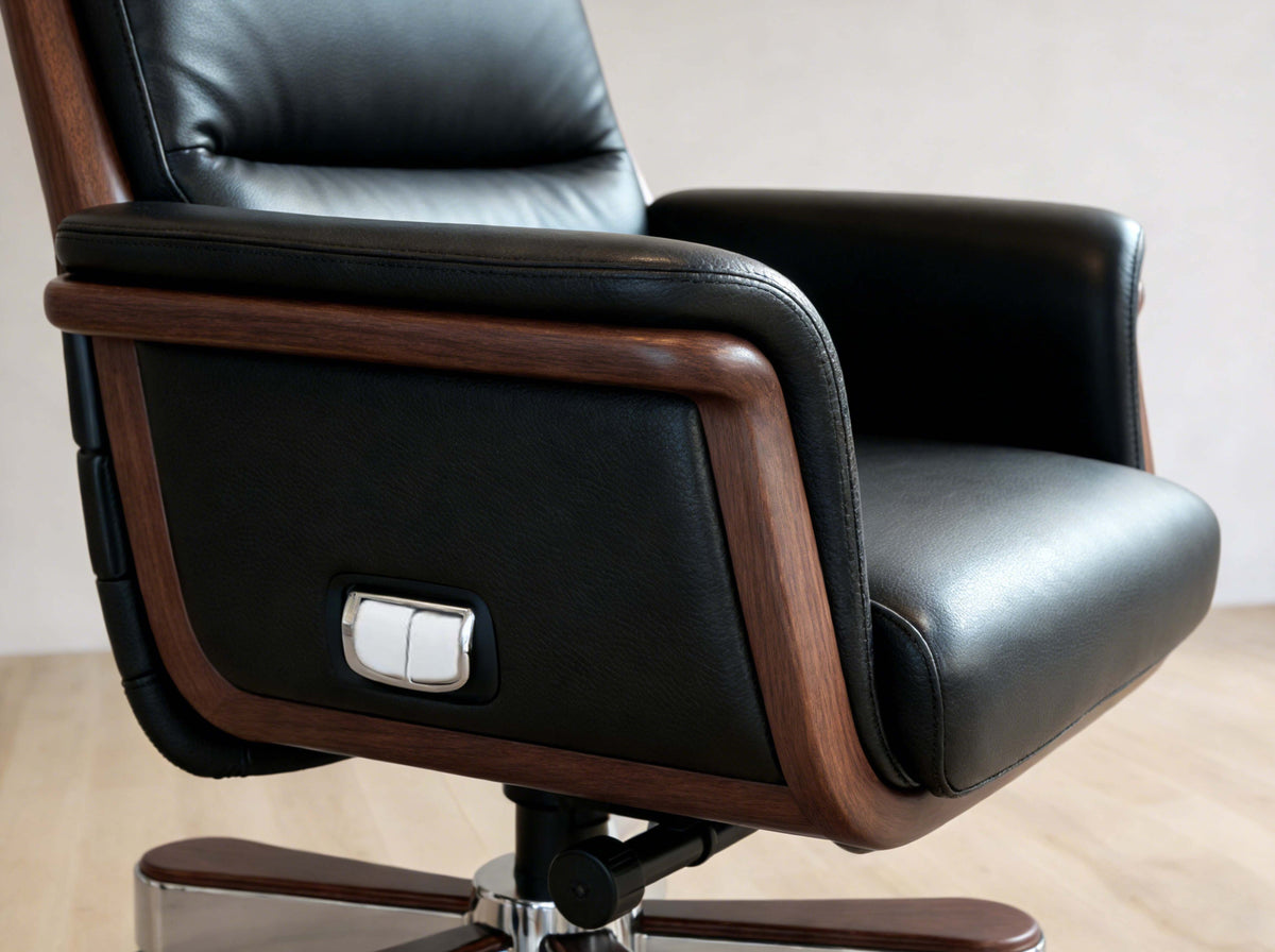 Black leather office chair with wooden armrests on a light wood floor.